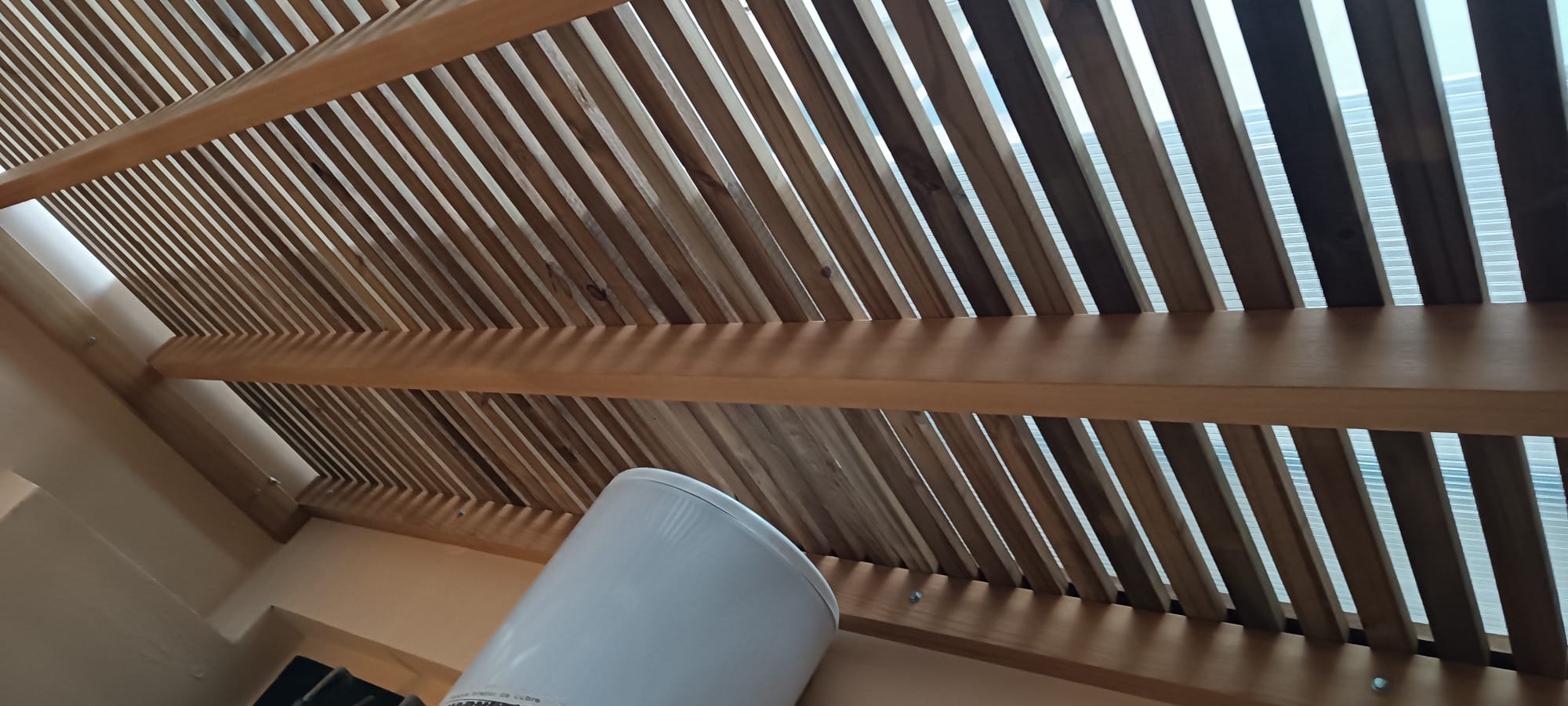 Cortasol de listones de madera visto desde abajo, detalle vigas