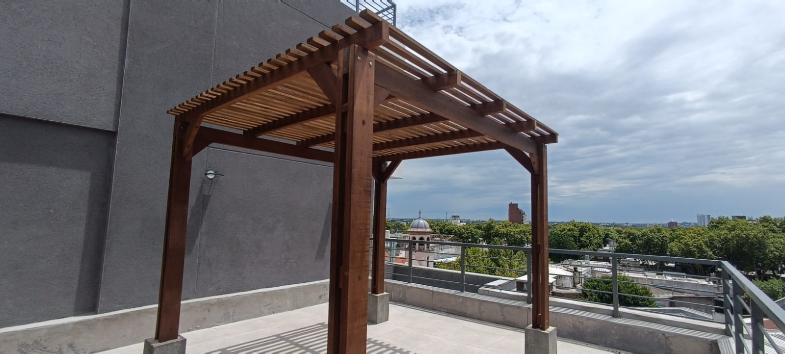 Pérgola de madera terminada en azotea con vista a la ciudad