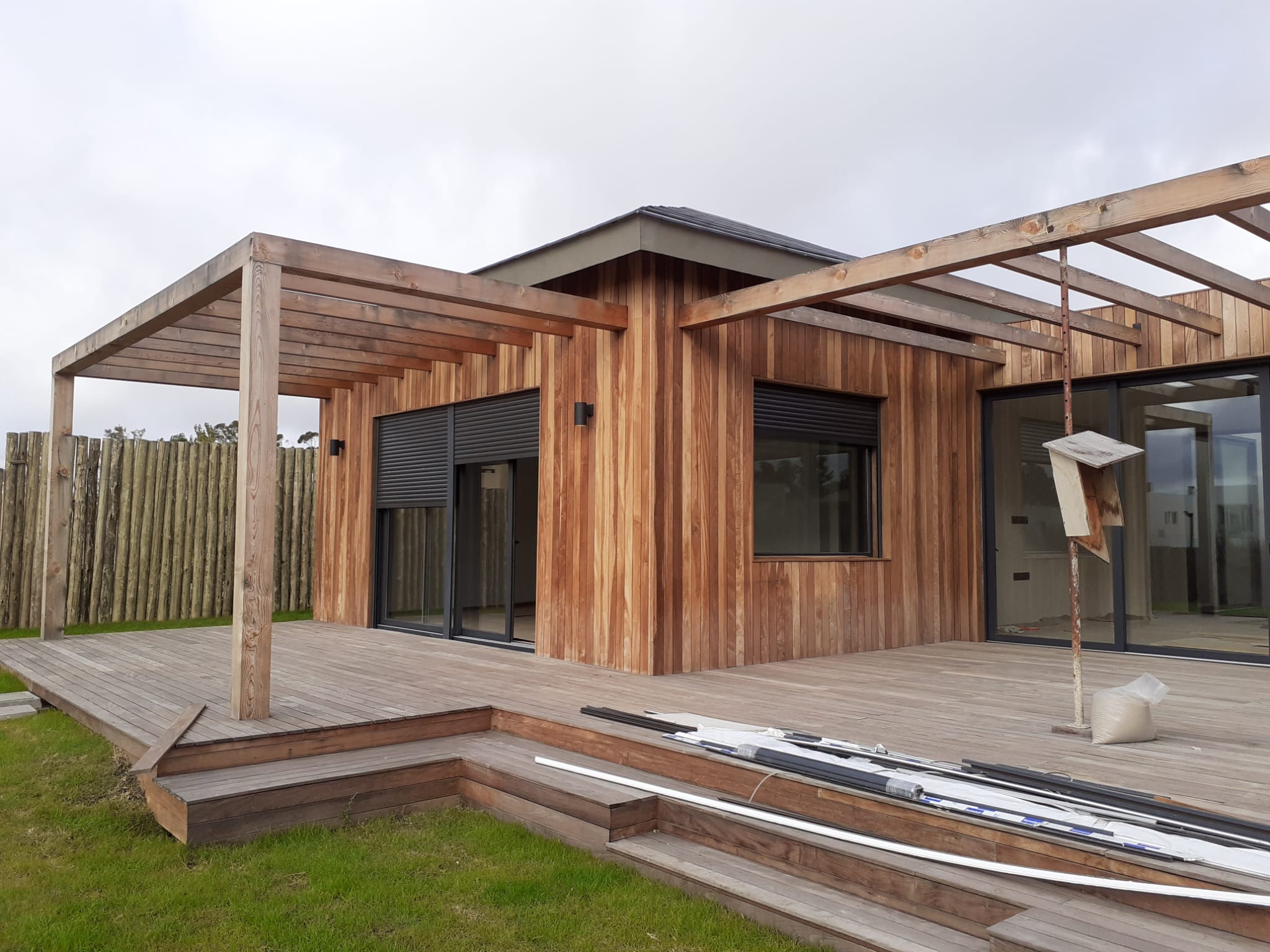 Casa con pergola de madera y deck, fachada en madera