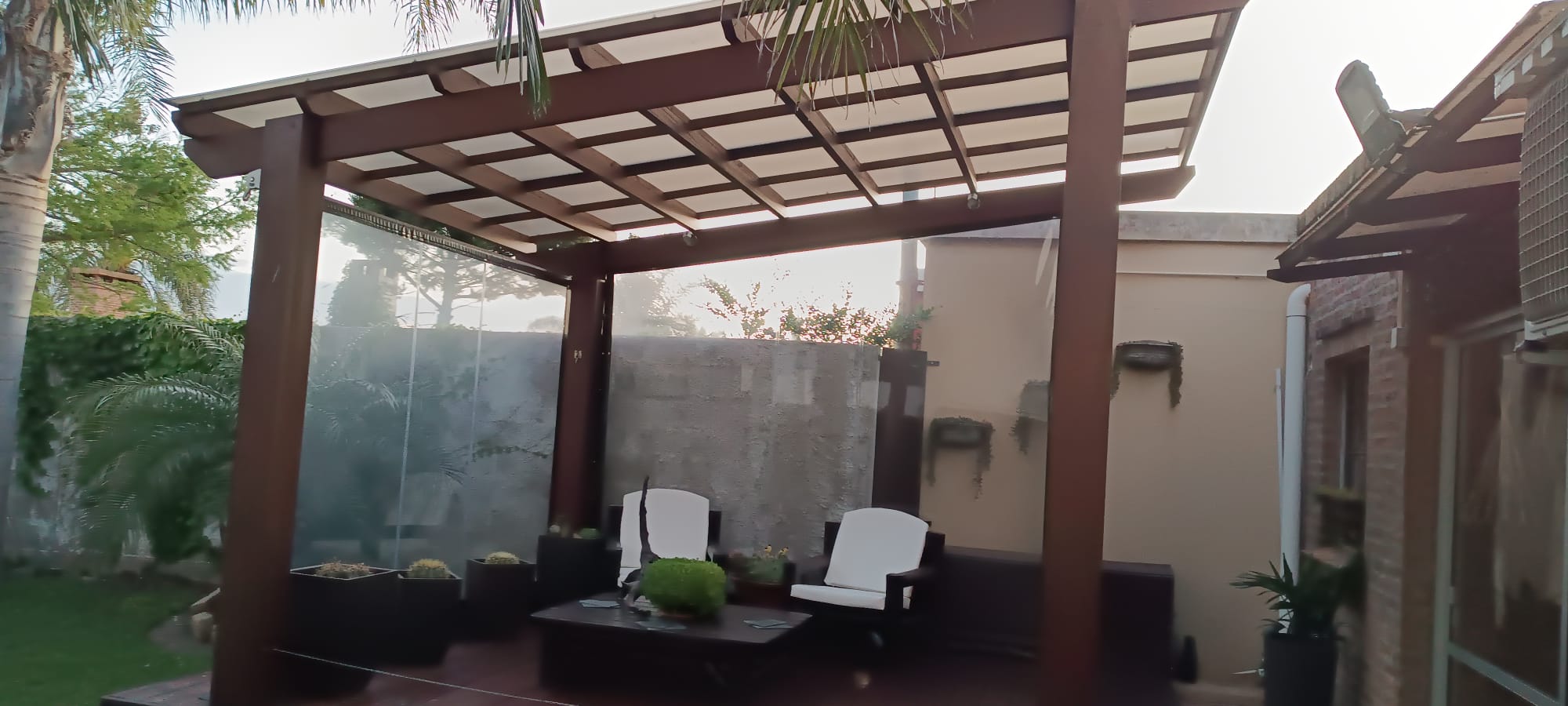 Pergola de madera con techo policarbonato sobre living exterior