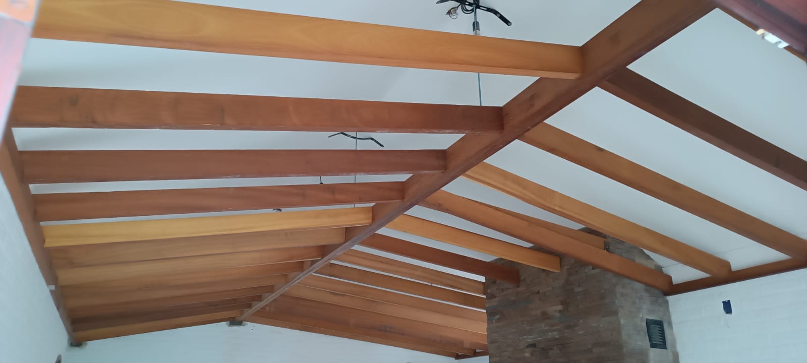 Estructura de vigas de madera a dos aguas con columna de piedra