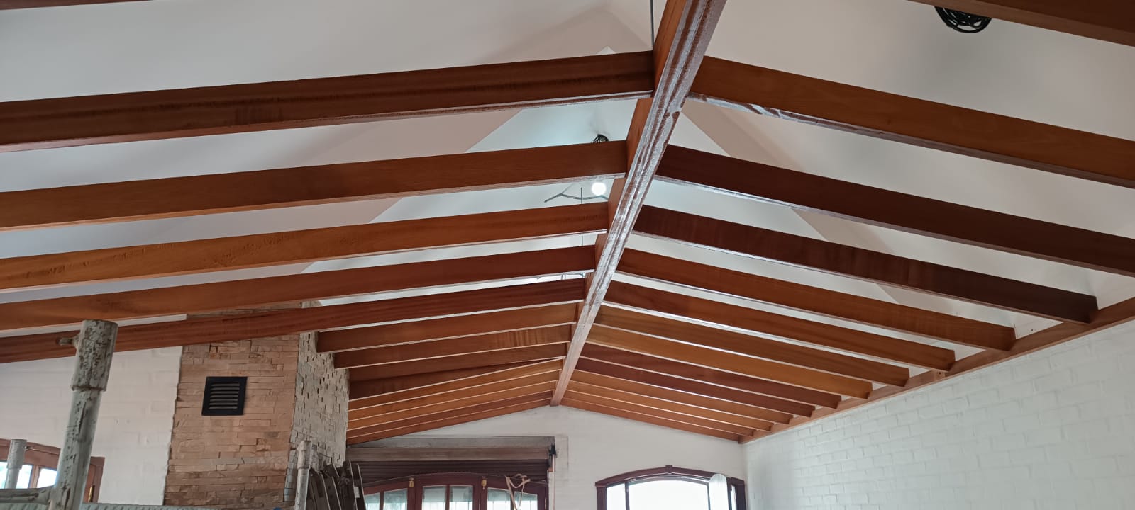 Techo de madera a dos aguas con vigas lustradas, interior